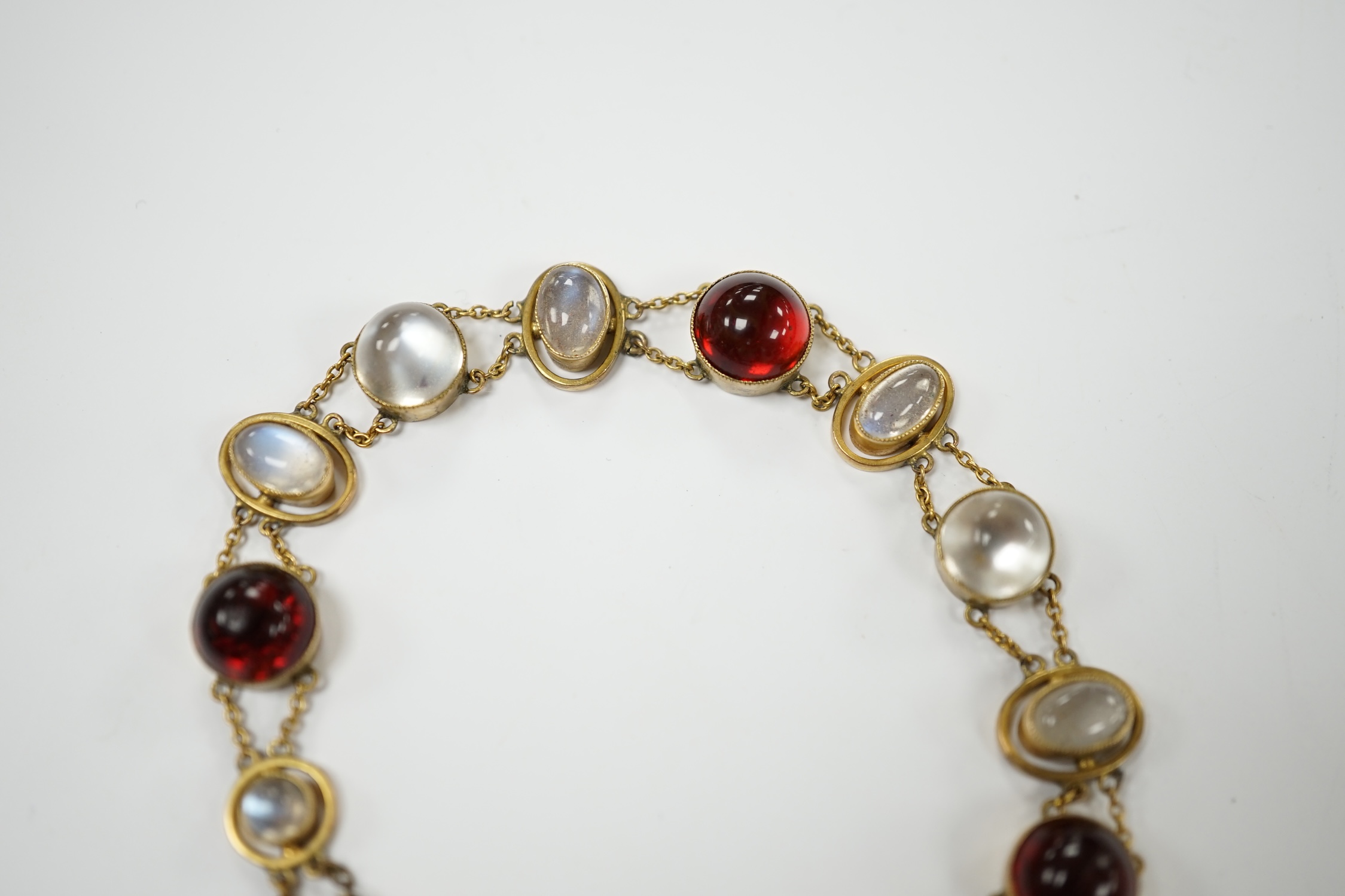 A George V 9ct, cabochon moonstone and cabochon red paste set bracelet, 16.5cm, gross weight 12 grams, Condition - fair